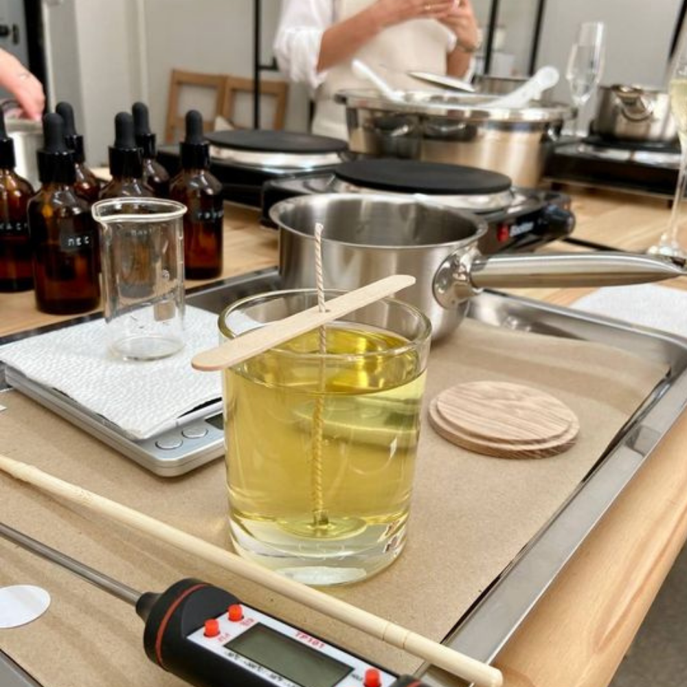 Na zdjęciu widać stanowisko do tworzenia świec, z akcesoriami i płynem w szklance, przygotowane prawdopodobnie dla warsztatów organizowanych przez Mistrzów imprez.